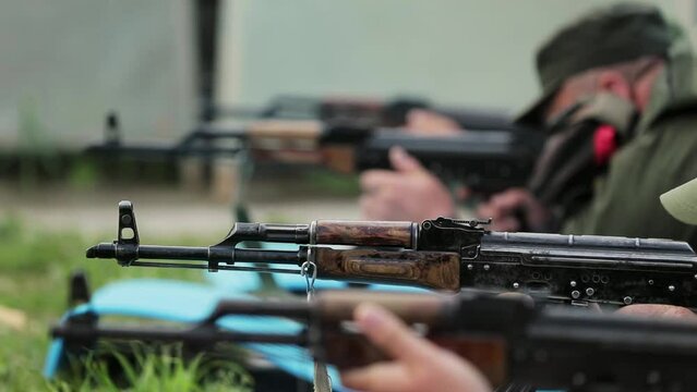 four Ukrainian soldiers are shooting prone with automatic weapons at the target. war in Ukraine. soldier training. shooting. close-up