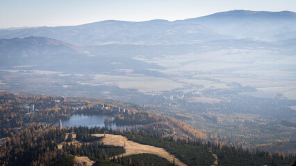 Romantic autumn landscape with mountains and village on a lake during foggy morning,Europe, Slovakia