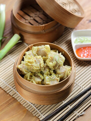 Siomay ayam, steamed dumpling dimsum with the main ingredients of chicken and shrimp. Served in traditional bamboo steamer on white background