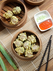Siomay ayam, steamed dumpling dimsum with the main ingredients of chicken and shrimp. Served in traditional bamboo steamer on white background