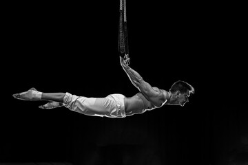 Muscular male air circus artist performances with dance trapeze 