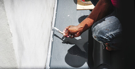 Construction workers repairing roof waterproofing waterproof roof.                                          