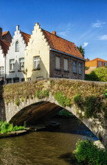 Fototapeta premium Bruges, Belgium vintage stone houses and bridge over canal