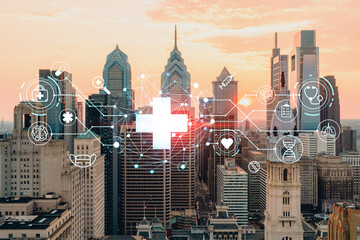 Aerial panoramic cityscape of Philadelphia financial downtown, Pennsylvania, USA. City Hall Clock Tower, sunset. Hologram healthcare digital medicine icons. The concept of treatment from disease