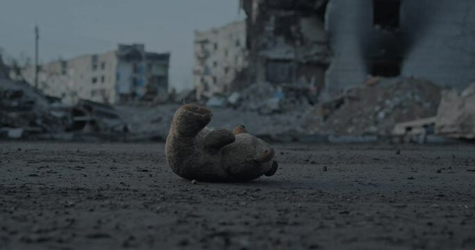 Kid's teddy bear lost among ruins of the bombed city