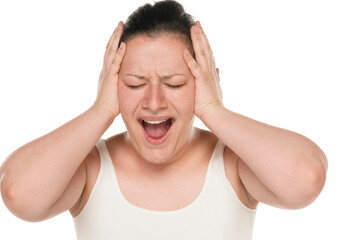 Naklejka premium Shocked panic young chubby caucasian woman over white background holding hands on head and screaming