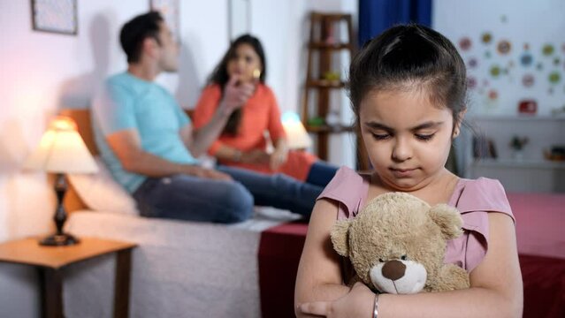 A married couple having an argument - dejected child sad girl unhappy family disturbed family. A little girl is feeling upset as her parents yell at each other - parents fighting  quarreling  a ...