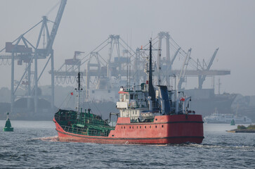 Naklejka premium OIL PRODUCTS TANKER - The red ship sails to fuel terminal at sea port 