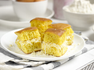 Martabak Keju, Indonesian Traditional Street Food Named Martabak Manis (Sweet Martabak) with Grated Cheese on WhiteTable. Selective focus