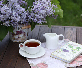 still life with morning cup of tea and lilac flowers