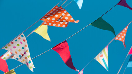 Banderines triangulares de fiesta de colores sobre cielo azul