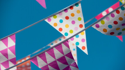 Banderines triangulares de fiesta de colores sobre cielo azul