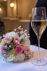 a bouquet of flowers and a champagne glass