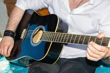 Musician with guitar. A melodic musical instrument. Acoustic guitar in hands