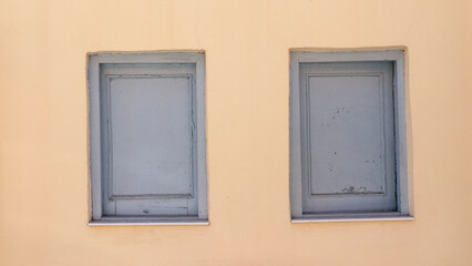 Ventanas de madera gris en pared amarilla