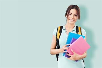 Young student woman wearing backpack and holding books