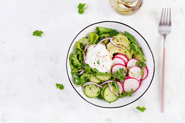 Vegetarian vegetable salad of radish, cucumbers, avocado and yogurt.  Healthy vegan food. Top view, above