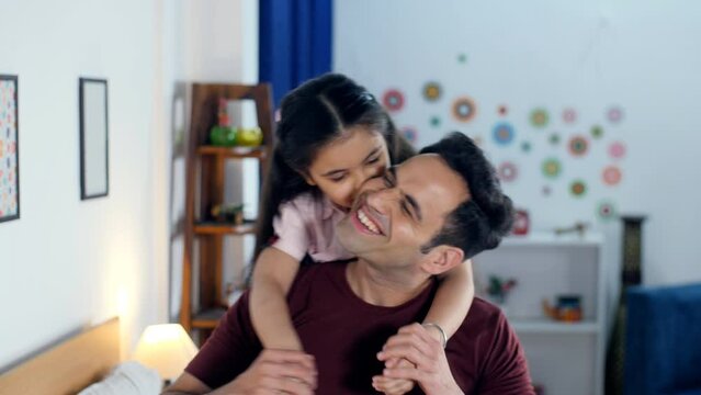A cute daughter playing guessing games with her father - Happy Indian father-daughter duo childhood in a happy family. An Indian girl surprises her father by covering his eyes from behind - Father...