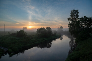 Fototapeta na wymiar Misty sunrise on a river