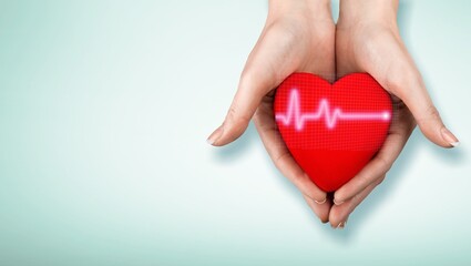 World Hypertension Day. Adult holds a red heart with a heartbeat chart, a symbol of high blood pressure.