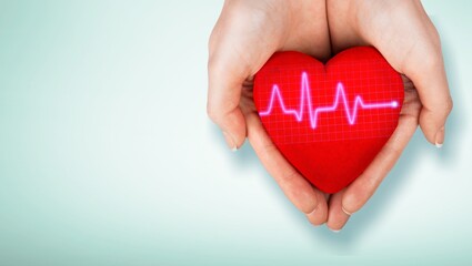 World Hypertension Day. Adult holds a red heart with a heartbeat chart, a symbol of high blood...