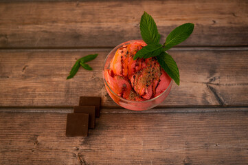 Strawberry sundae ice cream with chocolate, mint and syrup in glass cup
