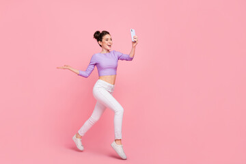 Fototapeta na wymiar Full length body size view of attractive cheery trendy girl jumping taking selfie isolated over pink pastel color background