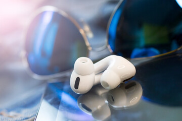 White wireless headphones and blue sunglasses