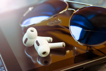 White wireless headphones and blue sunglasses