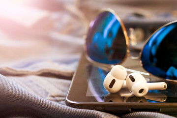 White wireless headphones and blue sunglasses