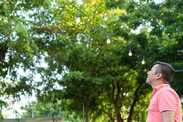 Latin man standing looking at the trees