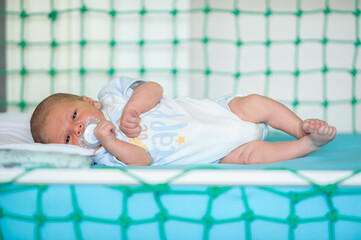 Cute little peaceful baby calm sleeps soundly in his crib in a bright room. Close-up portrait of beautiful child sleeping and resting