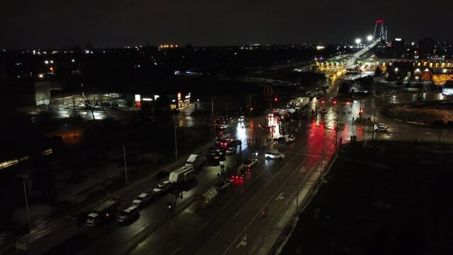 Drone shot of Freedom convoy in Windsor, Canada. Police officers in cars sitting and waiting. night time Canda. Lights flashing. Road block 
