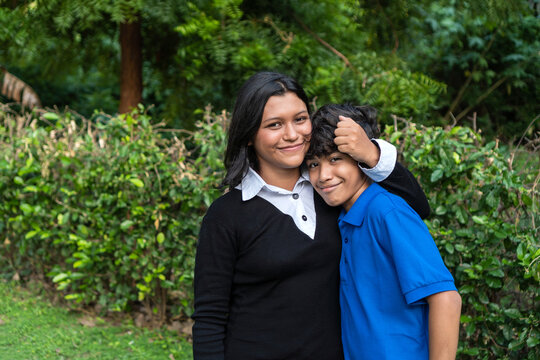 Portrait Of Teenage Latino Siblings Standing In Park