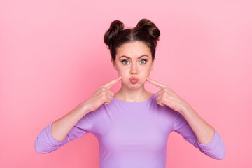 Portrait of attractive funny cheery girl blowing touching cheeks fooling isolated over pink pastel color background