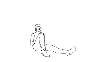 man in overhead headphones sits leaning against the wall - one line drawing vector. concept listening to music alone