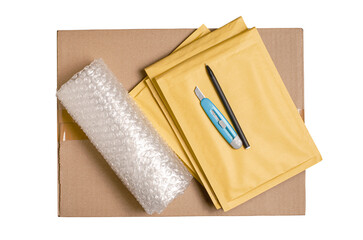 Cardboard box, smartphone, bubble wrap and packaging tools. The concept of packaging parcels for an online store. View from above. Isolated on a white background.