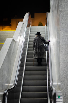 Old woman at train station on elevator stairs