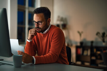 Serious-looking man checking some papers, working at the office,