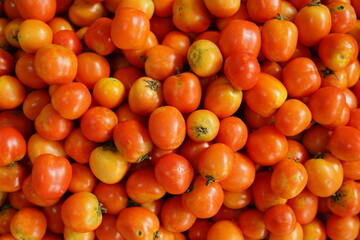 Top view Indonesian tomato fruit at Market Stalltop on the background of a basket with tomatoes.