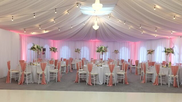 Gorges banquet hall decorated for wedding party with fresh flowers and white furniture