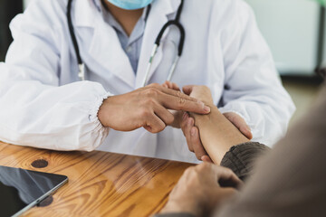Close-up, the doctor is doing a basic health check and measuring his pulse using his fingers.