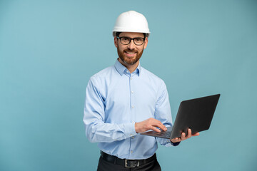 Young architect man with happy face in builder safety helmet smiling while looking at the camera...