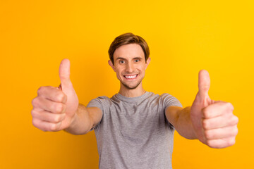 Young man wearing casual clothes over bright background approving doing positive gesture hand thumbs up smiling success