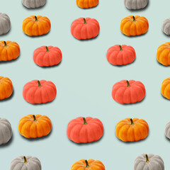 Autumn colorful pattern of pumpkins on pastel blue background with copy space. Trendy Halloween pattern with different color pumpkins. Creative autumn, fall concept. Side view.
