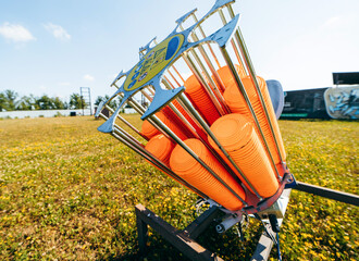 Close up plat machine with orange shooting plate for shooting-ground training on field with grass