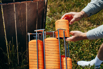 Close up hands of worker loading plat machine with orange shooting plate for shooting-ground...