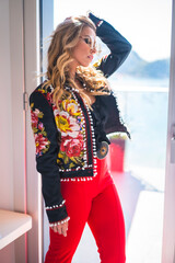 Fashion portrait of a blonde woman in the luxury room on vacation by the window