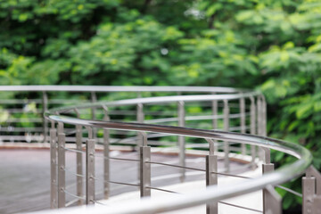 curve stainless steel handrail with garden background.