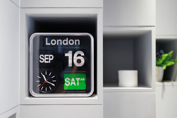 white flip clock on white shelf, retro analog timer. show time on 16 september at late morning,...